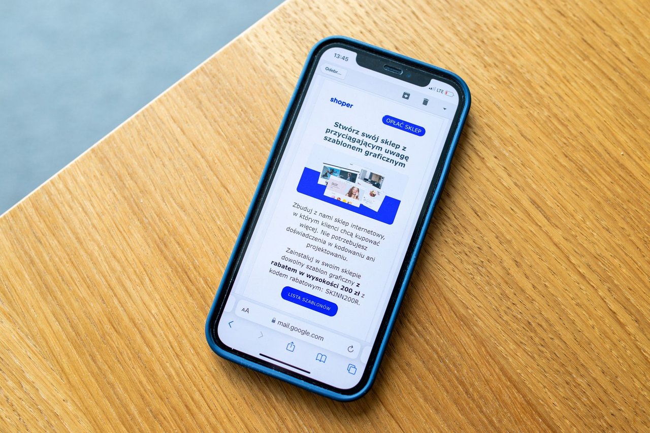 Smartphone exibindo um anúncio de comércio eletrônico sobre uma superfície de madeira.