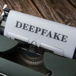 Close de uma máquina de escrever com a palavra “Deepfake” digitada em uma folha de papel.
